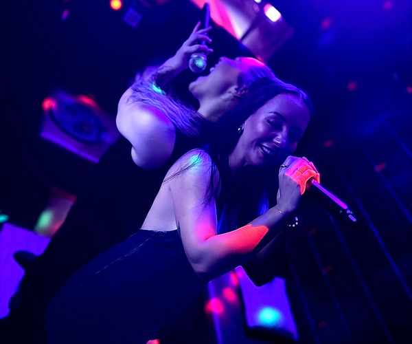 Two friends sharing the mic at karaoke at Spinners